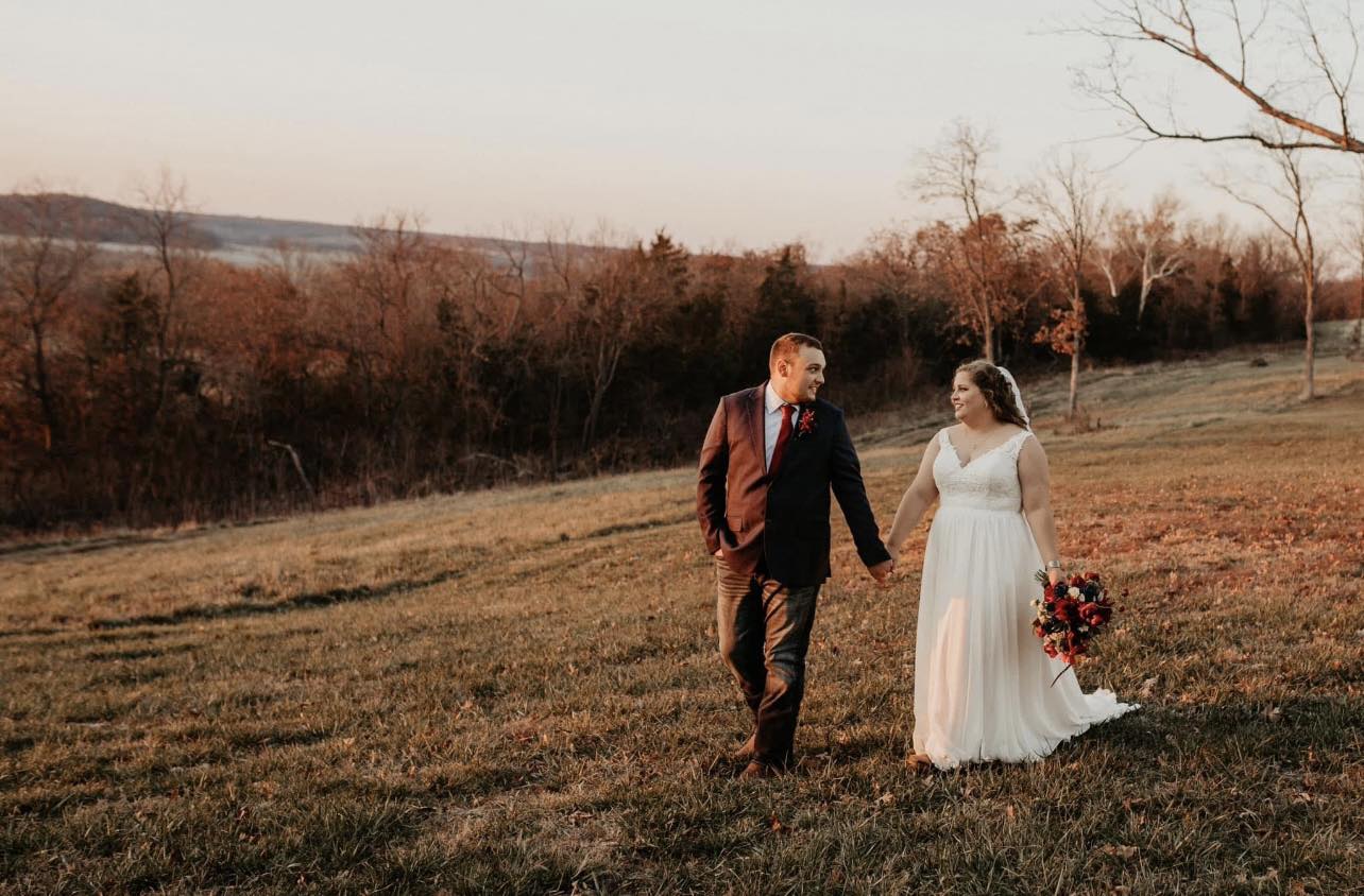 bride and groom walking on field